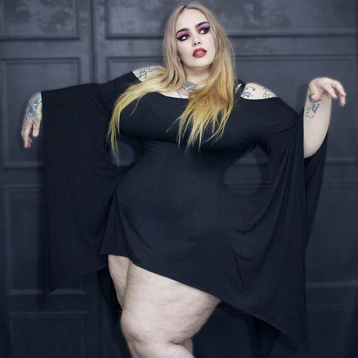 Lilith Fury wearing plus sized dark fashion, standing in a witchy pose.